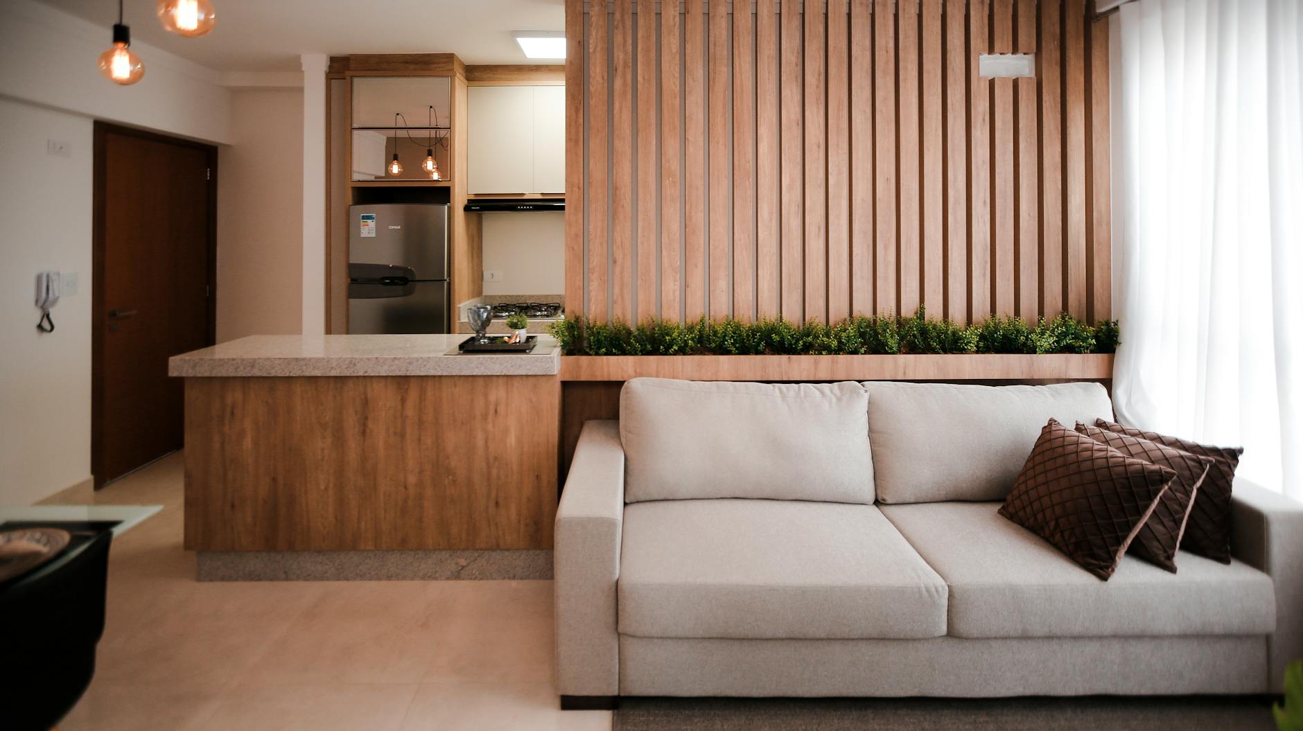 Elegant living room with a cozy couch and modern kitchen area, perfect for home interiors.