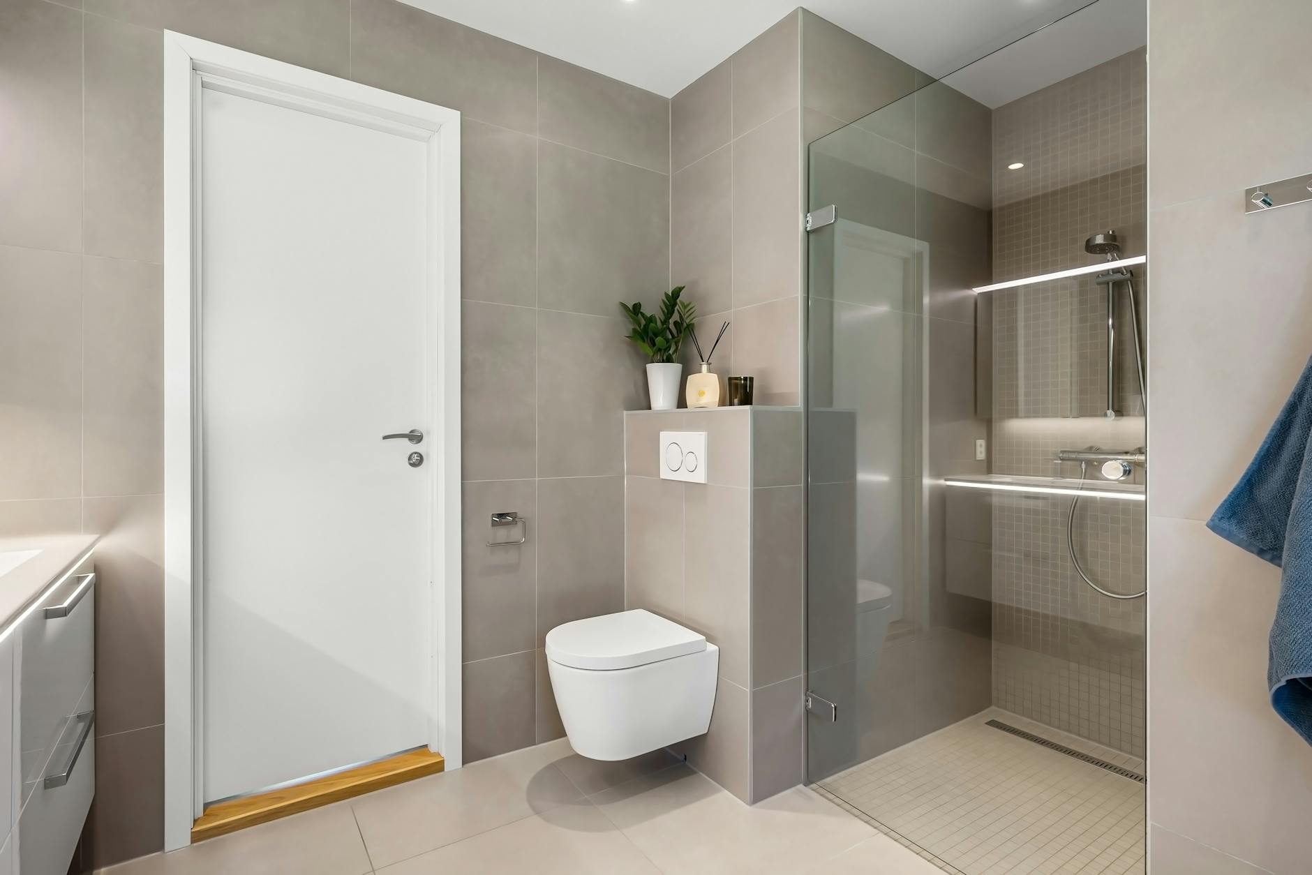 Sleek minimalist bathroom design featuring a glass shower enclosure and floating toilet.