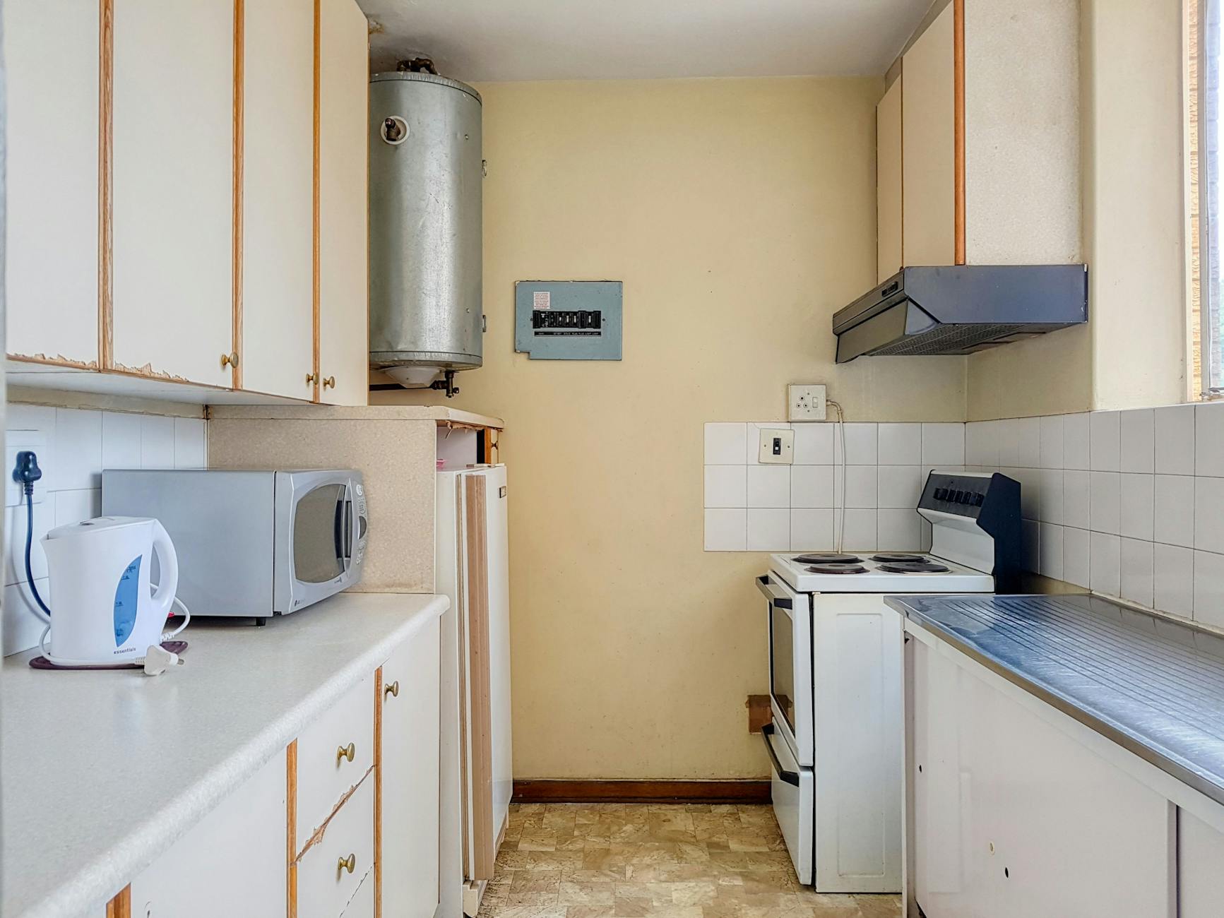 A compact kitchen featuring vintage appliances and contemporary design elements, perfect for a cozy home vibe.
