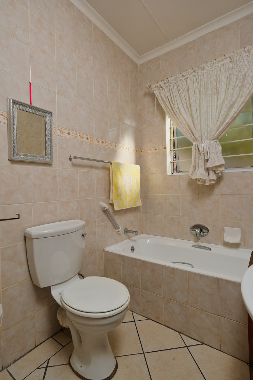 A well-lit and cozy bathroom with modern fixtures and a tiled design.