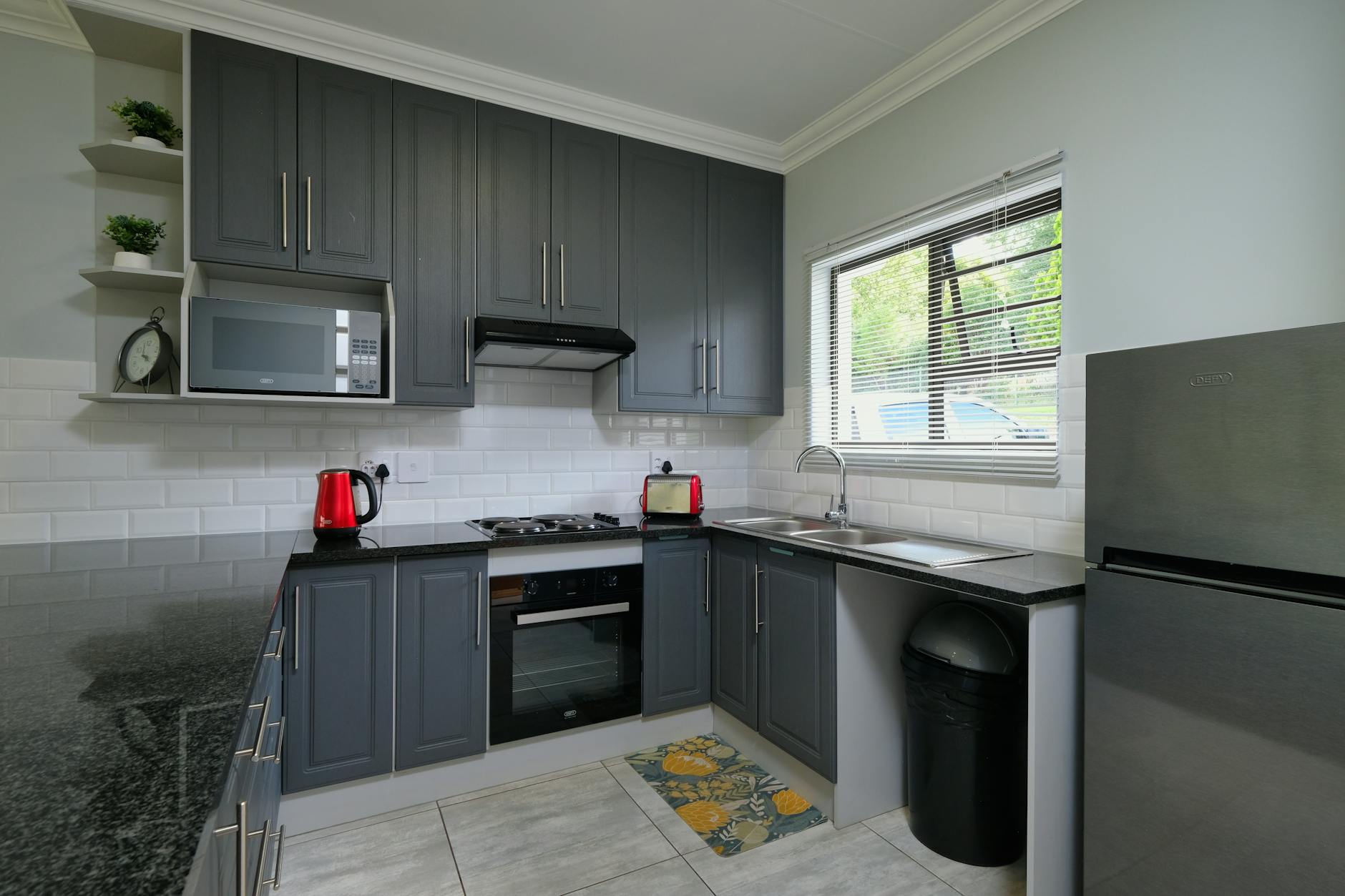 Sleek modern kitchen featuring dark cabinets and stainless steel appliances.