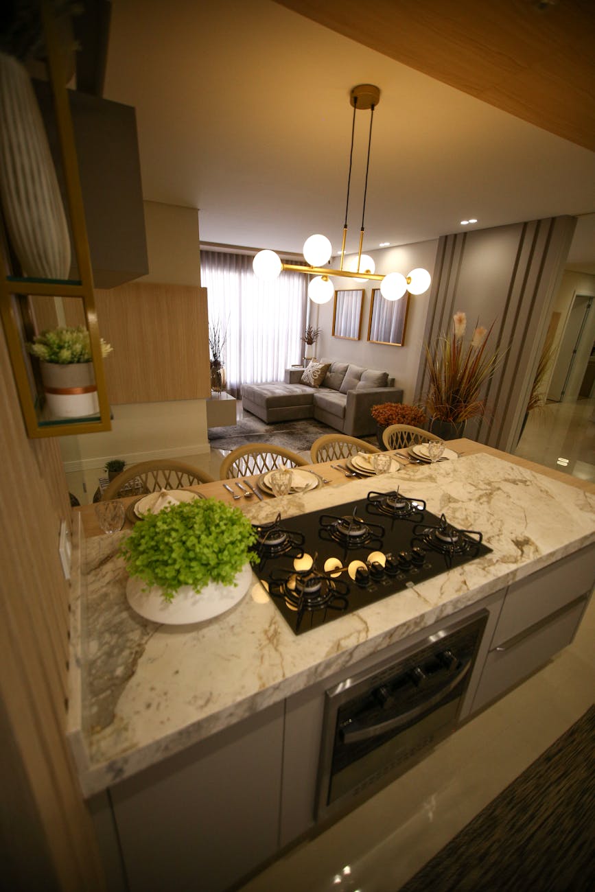 Elegant kitchen interior featuring a marble countertop, wooden accents, and decorative lighting.