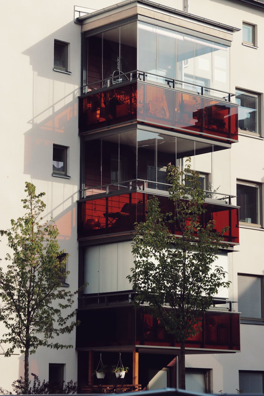 Stylish apartment building in Sweden with striking red balconies and modern architecture.