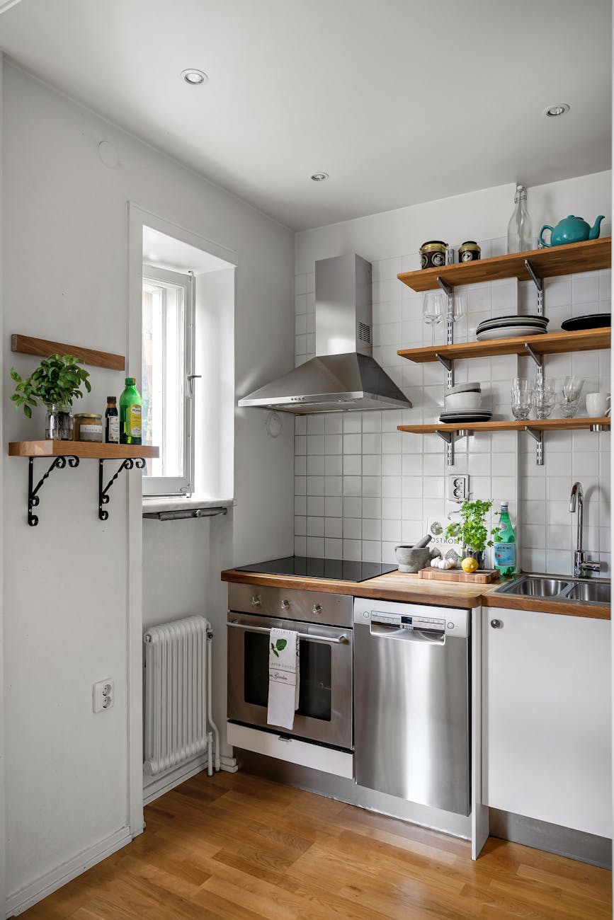 Sleek, minimalist kitchen with stainless steel appliances and open shelving. Ideal for modern interiors.