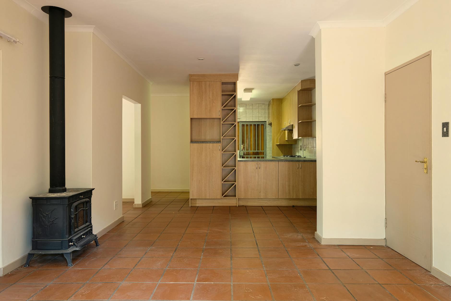 Spacious living area with a modern kitchen, warm tones, and a wood-burning stove.