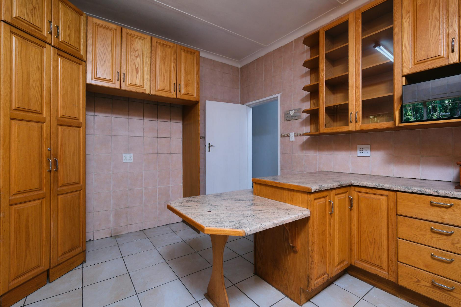 Modern kitchen interior with wooden cabinets and granite countertops.