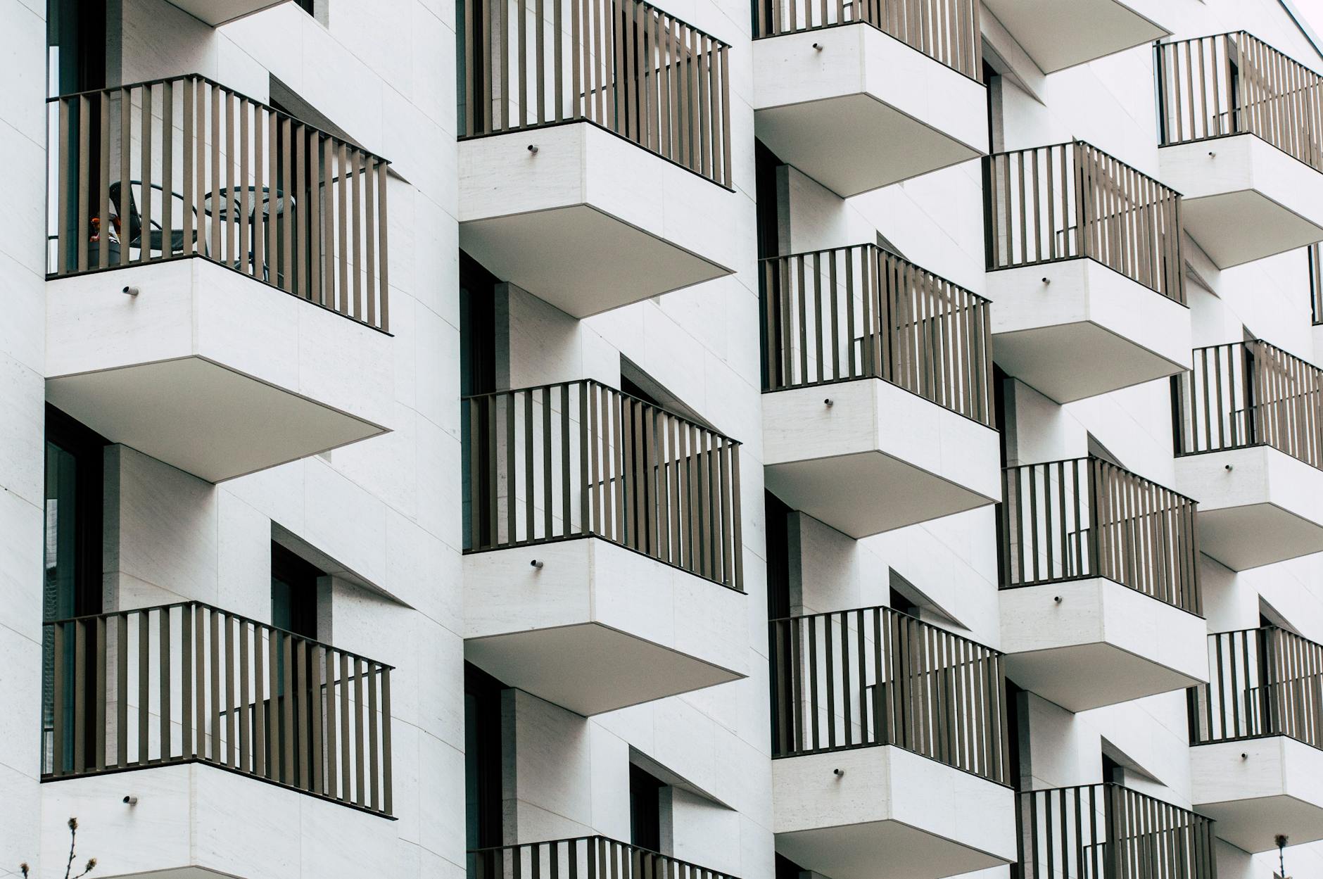 Urban apartment building with geometric balconies in modern architectural style.